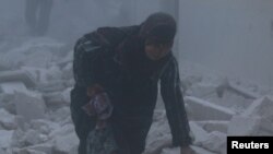 Zenan maşgala howa hüjümlerinden gutulmaga çalyşýar, Alepponyň al-Ansari etraby, 7-nji dekabr, 2016