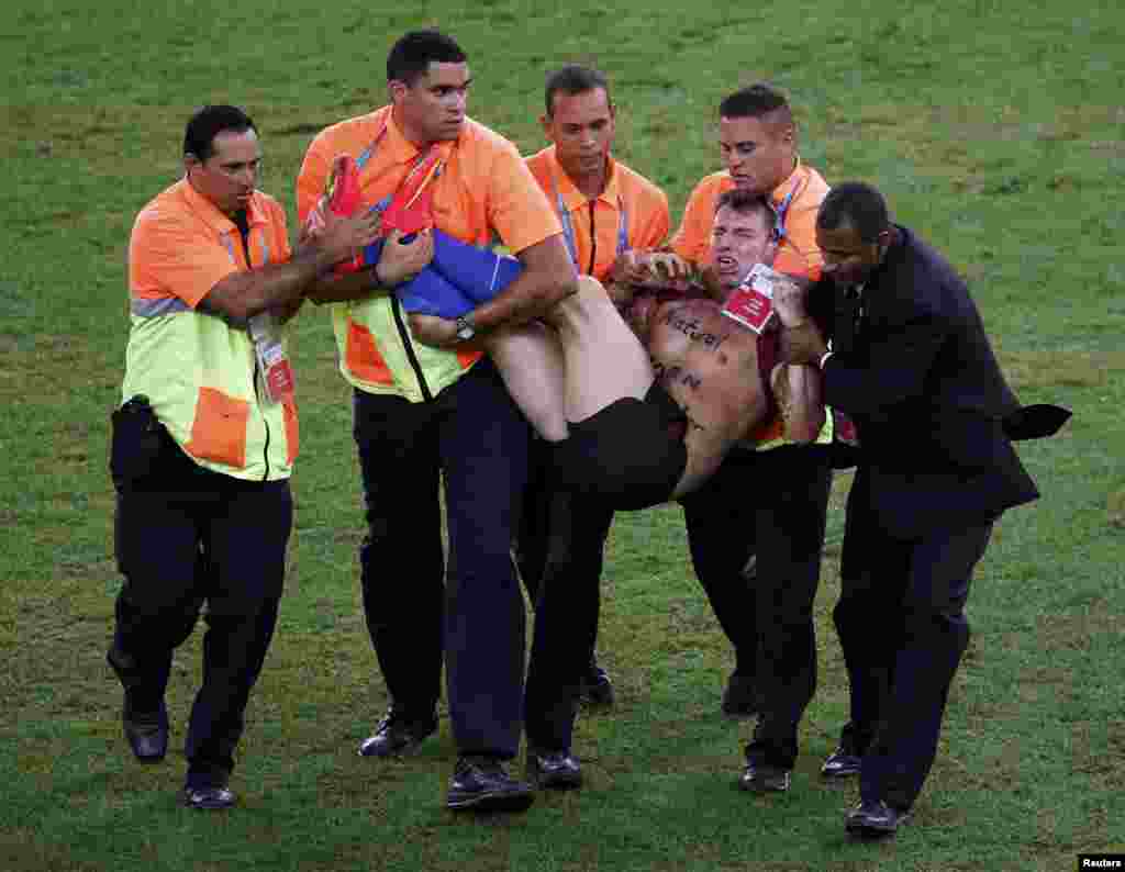 A pitch invader is carried off after getting caught during the 2014 World Cup final between Germany and Argentina at the Maracana stadium in Rio de Janeiro July 13, 2014. 