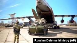Руски военни товарят танк в самолет по време на оттеглянето на войските от Крим на 22 април 2021 г. 