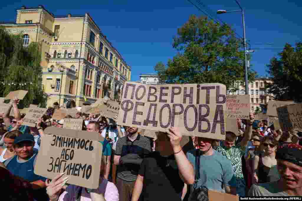 Людина ліворуч на фото тримає картонку з написом: «Змінимось, або загинемо»