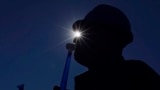 A Romanian demonstrator blows a plastic trumpet during a labor union protest of miners, steelmakers, and energy sector workers held in front of government headquarters in Bucharest on October 17.