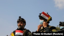 Pripadnici iračkih snaga bezbednosti sa zastavama Iraka i Vatikana čekaju papin dolazak u Bagdad