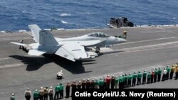 Sailors line up and watch Capt. William R. Reed, commander of Carrier Air Wing (CVW) 7, launch from the flight deck of the Nimitz-class aircraft carrier USS Abraham Lincoln in Arabian Sea, May 30, 2019. 