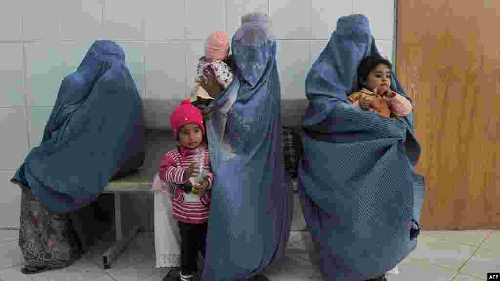 Women wait with their children for polio vaccinations on the second day of a vaccination campaign in western Afghanistan in October. Attackers have targeted health workers there, too, including a deadly shooting in eastern Afghanistan on December 1. (AFP/Aref Karimi)