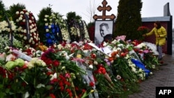 A mourner lays flowers on the grave of Russian opposition leader Aleksei Navalny at the Borisovskoye cemetery in Moscow on March 2, the day after Navalny's funeral.