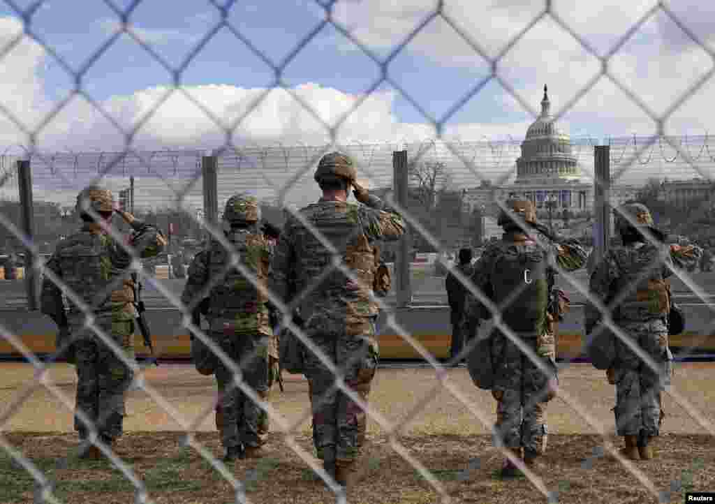Військовослужбовці Національної гвардії США салютують перед будівлею Капітолію США під час інавгурації президента Джо Байдена