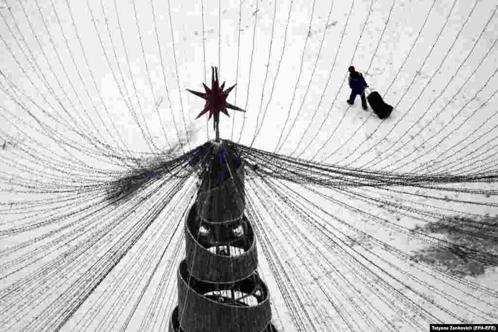 A man with a bag walks under a seasonal New Year Tree on a winter&#39;s day in central Minsk, Belarus. (epa-EFE/Tatyana Zenkovich)