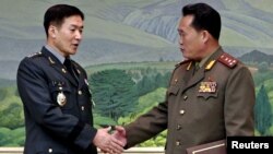 Korea -- South Korean colonel Moon Sang-kyun (L) and his North Korean counterpart colonel Ri Shin-kwon pose before their talks at the Peace House on southern part of the truce village of Panmunjom in the demilitarized zone in Paju, 30Sep2010