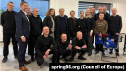 Група палітвязьняў разам з Джонам Коўлам, спэцыяльным пасланьнікам прэзыдэнта ЗША