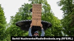 Журналіст Олександр Кужельний (видання «Букви», яке не акредитували на пресконференцію) стоїть із запитаннями до президента в парку, неподалік від Маріїнського палацу, де відбувалася у цей час пресконференція. Київ, 20 травня 2020 року 