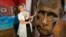 Artista ucraineană Daria Marcenko cu un portret al lui Putin intitulat "Chipul războiului", realizat din cartușe trase pe front.