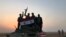 Syrian forces gestures as they carry the national flag in the village of Suway'iah, near the Syrian border town of Albu Kamal, on November 9, 2017. File photo