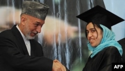 Afghan President Hamid Karzai shakes hands with a female student during a university graduation ceremony in Kabul.