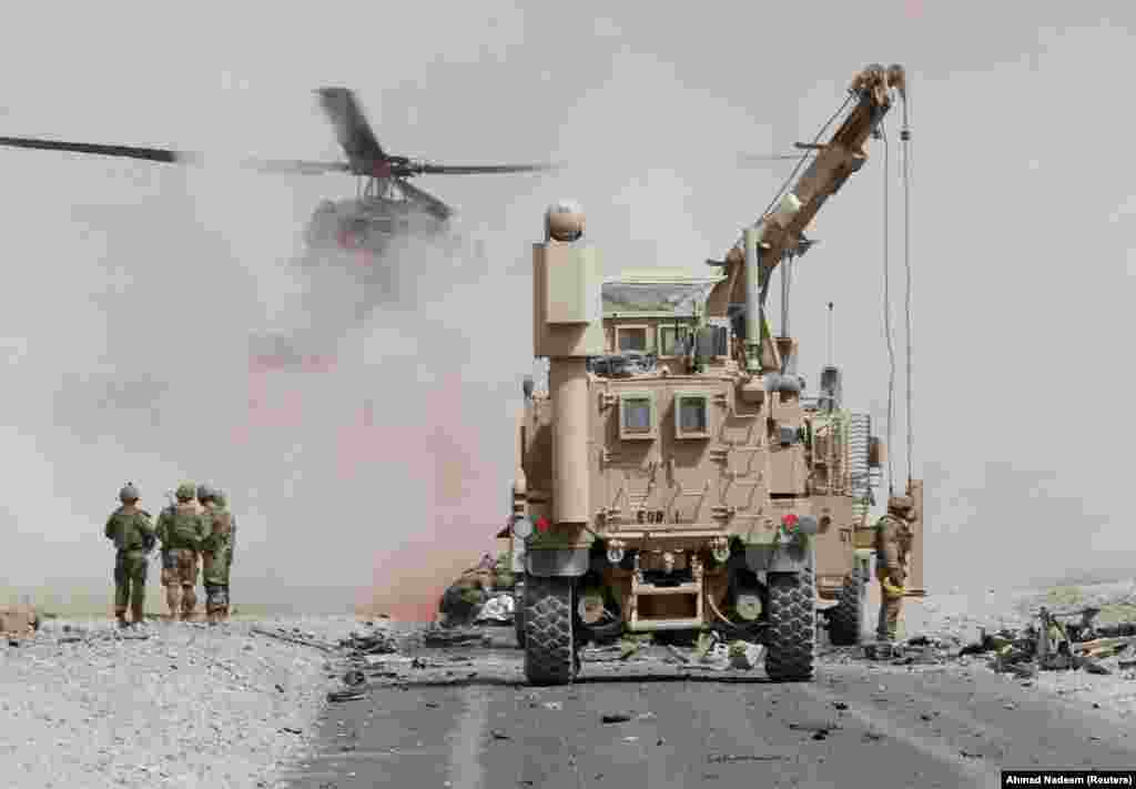 U.S. troops assess the damage to an armored vehicle belonging to the NATO-led military coalition after a suicide attack in Kandahar Province, Afghanistan. (Reuters/Ahmad Nadeem)