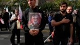 عکس امیرعلی حاجی‌زاده، فرمانده پیشین هوافضای سپاه پاسداران، در دست یکی از هواداران جمهوری اسلامی پس از کشته شدن او در بمباران نیروی هوایی اسرائیل