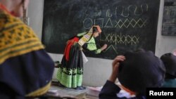 A teacher writes letters from the Kalasha alphabet on a blackboard during a lesson at the Kalasha Dur school and community center in Brun village, located in Bumburet Valley.