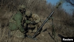 Ukrainian soldier fire a mortar on the front line in Bakhmut.