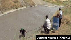 Семья достает воду из канала рядом с селом Гедик. 28 июня 2013