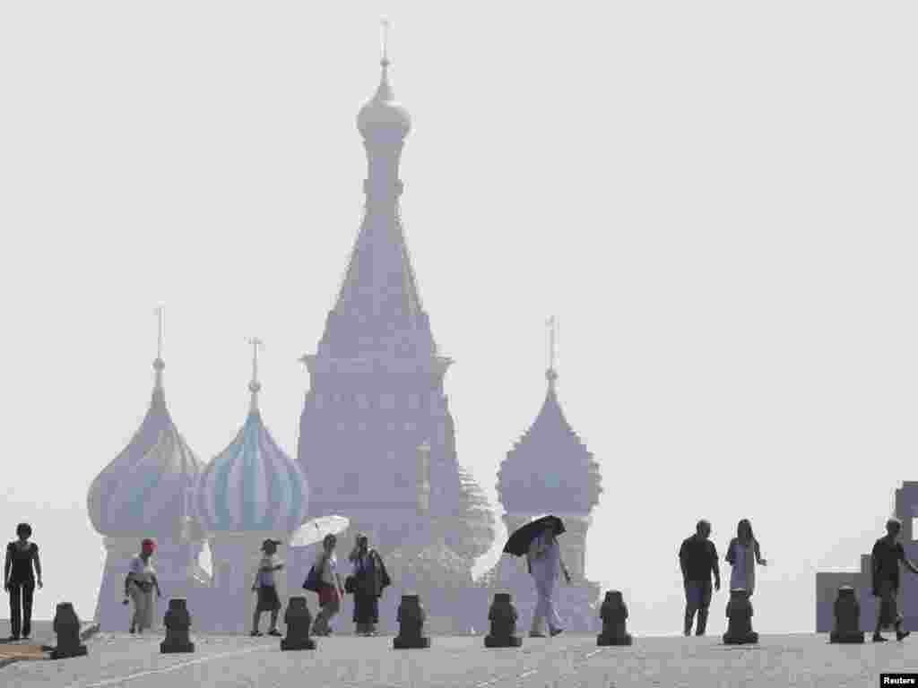 People walk along Red Square, with St. Basil's Cathedral seen through heavy smog caused by peat fires outside Moscow on July 26. Photo by Sergei Karpukhin for Reuters