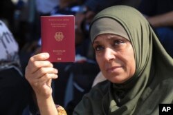 Палестинська жінка показує свій німецький паспорт на прикордонному переході «Рафах», 14 жовтня 2023 року