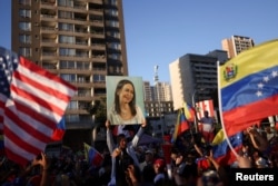 Венецуелци празнуват в Чили залавянето на Мадуро. На снимката човек държи снимка на лидерката на венецуелската опозиция Мария Корина Мачадо. 3 януари 2026 г.