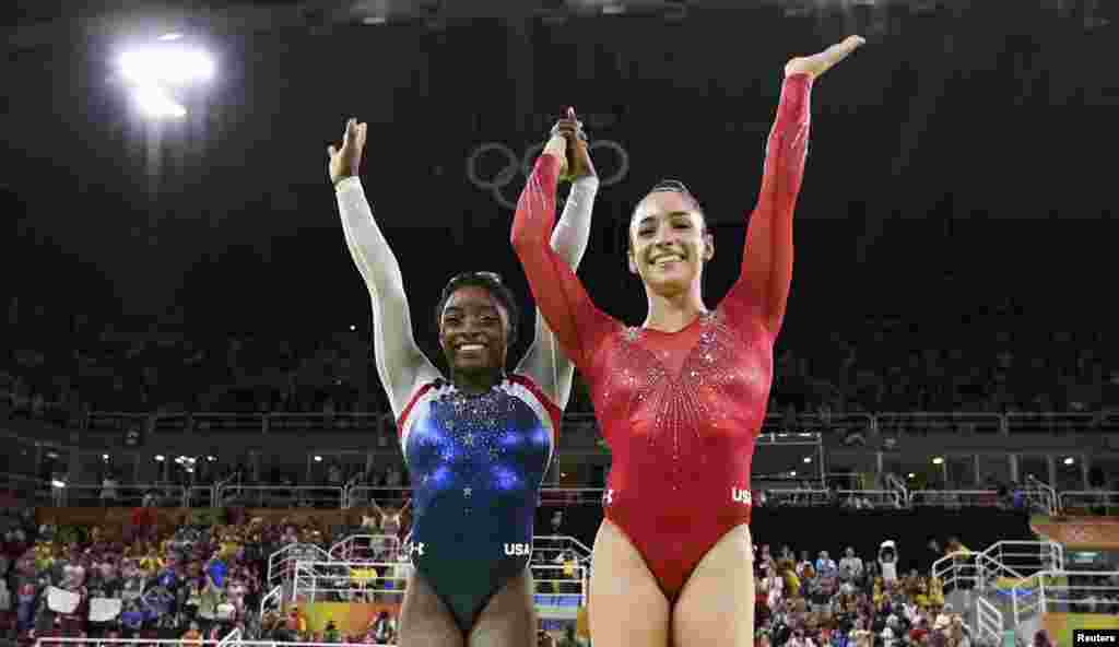 U.S. gymnasts Simone Biles (left) and Aly Raisman celebrate winning gold and silver respectively in the women&#39;s individual all-around final.&nbsp;