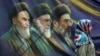 A woman in Tehran walks past a banner bearing portraits of the late founder of the Islamic republic, Ayatollah Ruhollah Khomeini (left), former Supreme Leader Ayatollah Ali Khamenei (center), and current supreme leader, Mojtaba Khamenei. 
