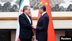 Chinese Foreign Minister Wang Yi (right) meets with his Iranian counterpart, Abbas Araqchi, in Beijing on May 6.