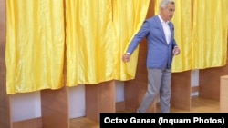 Călin Georgescu iese dintr-o secție de vot. El a candidat pentru Președinția României în 2024, înainte ca alegerile să fie anulate. 