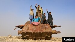 Afghan children play on the remains of a Soviet-era tank on the outskirts of Jalalabad. 