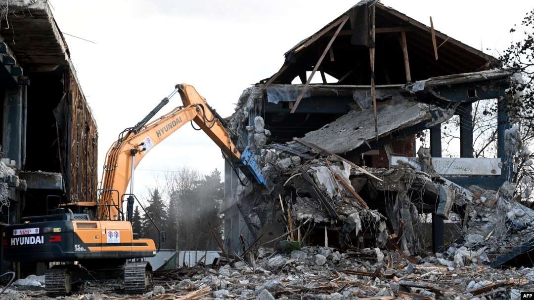 Croatia - Workers with heavy machinery demolish a house in Petrinja, 4Feb2021.