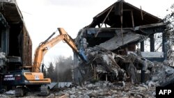 Croatia - Workers with heavy machinery demolish a house in Petrinja, 4Feb2021.