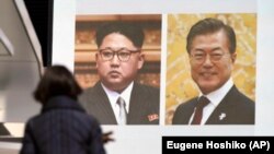Plakat sa slikom predsednika Severne i Južne Koreje Kim Džong Una i Mun Džae Ina.