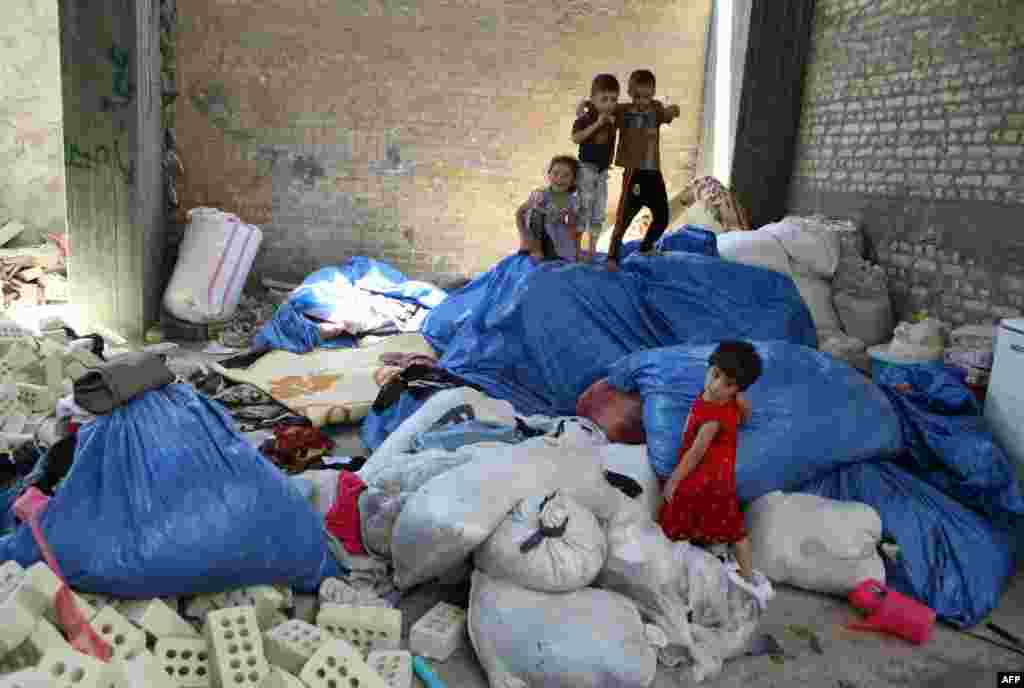 Displaced Iraqi children from the northern city of Mosul play in a building under construction on the outskirts of Baghdad, where they are taking shelter after fleeing clashes between Islamist State militants and Kurdish troops. (AFP/Amer Al-Saadi)