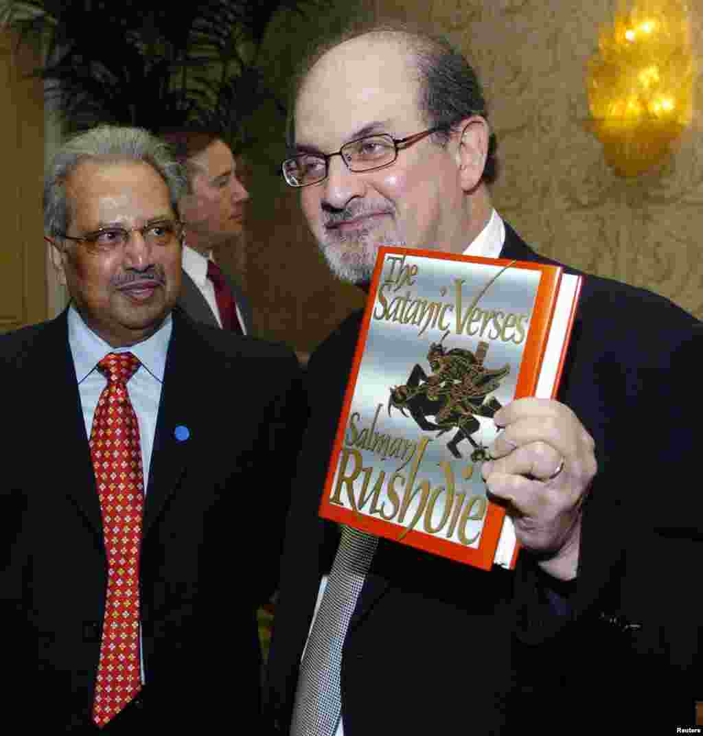 Salman Rushdie (right) poses with his 1988 book &quot;The Satanic Verses&quot; alongside fellow honoree Tashbih Sayyed before the American Jewish Conference&#39;s 30th annual dinner in Beverly Hills, California, in September 2006.