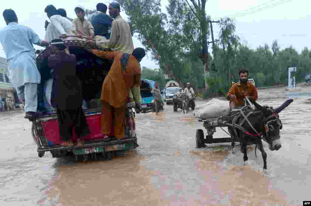 Pakistanis cross a flooded street in Peshawar. 