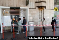 Кияни в захисних масках тримають дистанцію в черзі до ресторану МакДональдс. Київ, 13 травня 2020 року