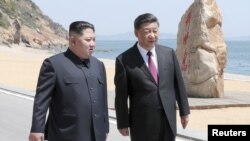 Xi Jinping (dreapta) și Kim Jong Un, la Dalian