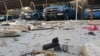 Police vehicles are parked next to debris in the Anbar town of Hit earlier this month. 