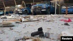 Police vehicles are parked next to debris in the Anbar town of Hit earlier this month. 