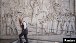 Muškarac prolazi pored bareljefa koji prikazuje fašističkog vođu Benita Mussolinija u naselju EUR poznatom po fašističkoj arhitekturi, u Rimu, Italija, 19. oktobar 2022. (Ilustrativna fotografija)