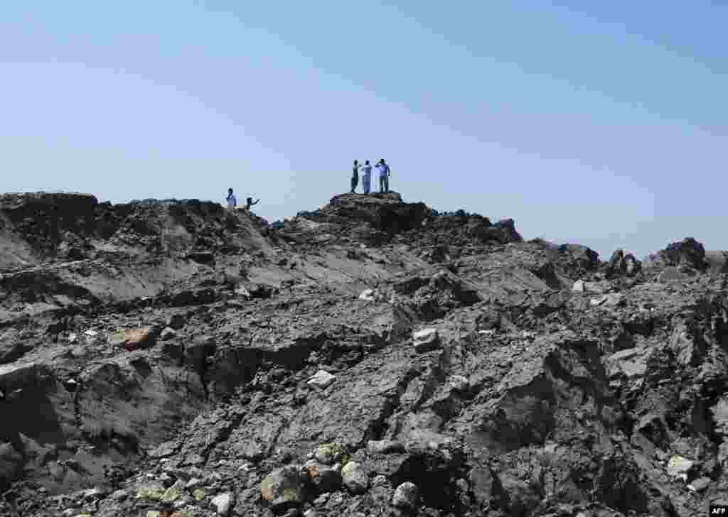 Men walk on the new island that appeared 2 kilometers off the Pakistani coast.