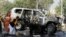 Rescue personnel inspect a vehicle damaged by a suicide bomber that killed a senior Pakistani police official on his way to work in Peshawar on November 24.