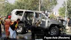 Pakistani security officials at the scene of a bomb attack that targeted a senior police officer in Peshawar on November 24.