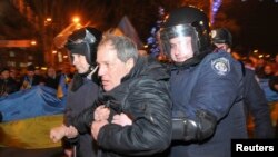 Украин полициясы Донецк шаарындагы тынчтыкка чакырган жыйын маалындагы кагылышууларга катышкан орусиячыл демонстрантты кармап кетүүдө. 05.3.2014.