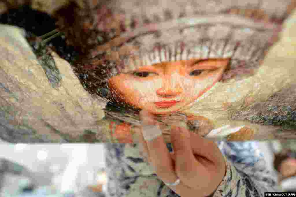 زن چینی در حال گلدوزی سنتی به مناسبت روز جهانی زن؛ یانگ&zwnj;ژو.