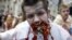 Un protestatar costumat în zombie ține în gură o bucată de ziar și mai multe panglici Sf.Gheorghe la o demonstrație împotriva propagandei ruse, Kiev, 21 iunie 2015.