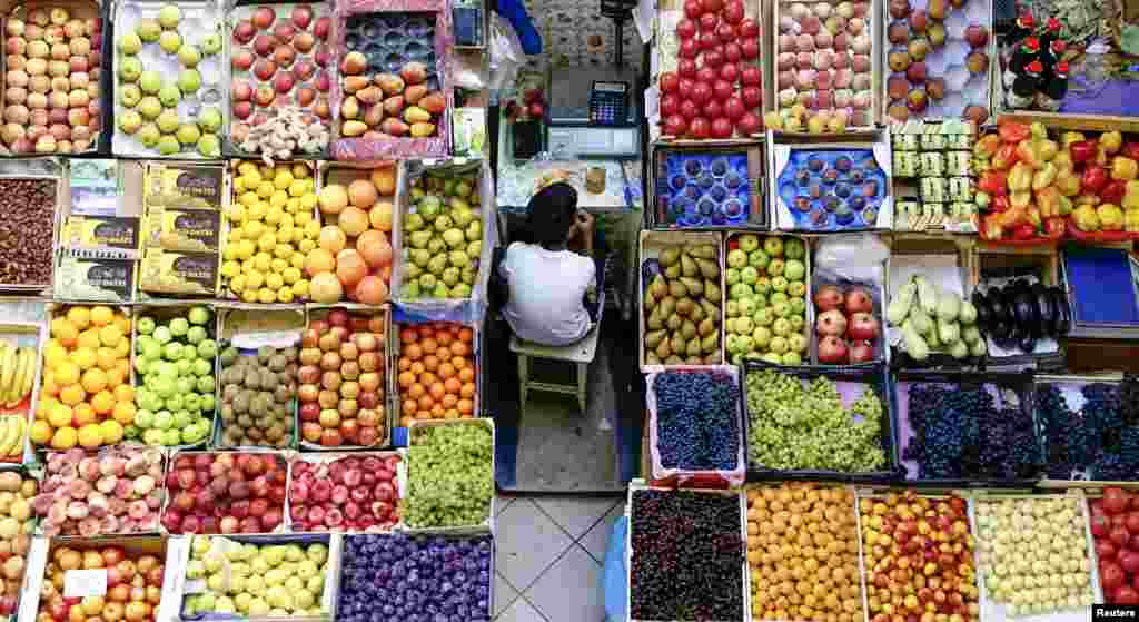 A boy takes a meal break at a fruit stall in the central market in Kazan, Russia. (Reuters/Hannibal Hanschke)