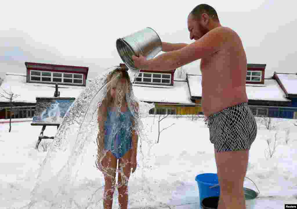 Grigory Broverman, a member of the Cryophile winter-swimmers club, pours a bucket of cold water over his 9-year-old daughter Liza during a celebration of Polar Bear Day at a zoo in Krasnoyarsk, Russia, on November 24. (Reuters/Ilya Naymushin)