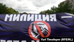 Protesters hold a banner reading "Militia [police] -- time to change" at a demonstration against police despotism.